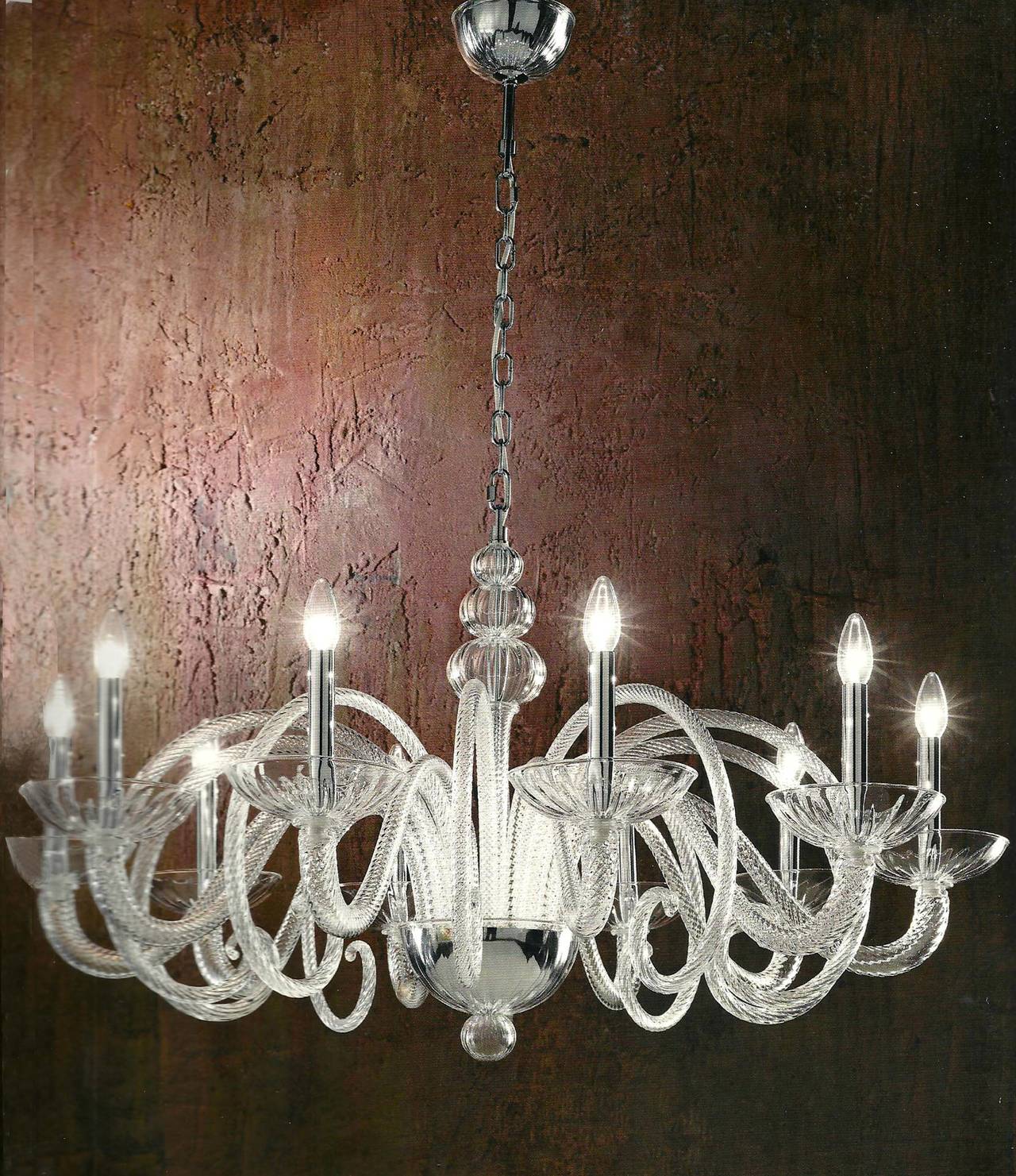 Gran araña de cristal veneciano soplado a mano de estilo Barovier e Toso en cristal transparente y con diez brazos curvos en espiral. 

El candelabro en sí (sin cadena) mide 24