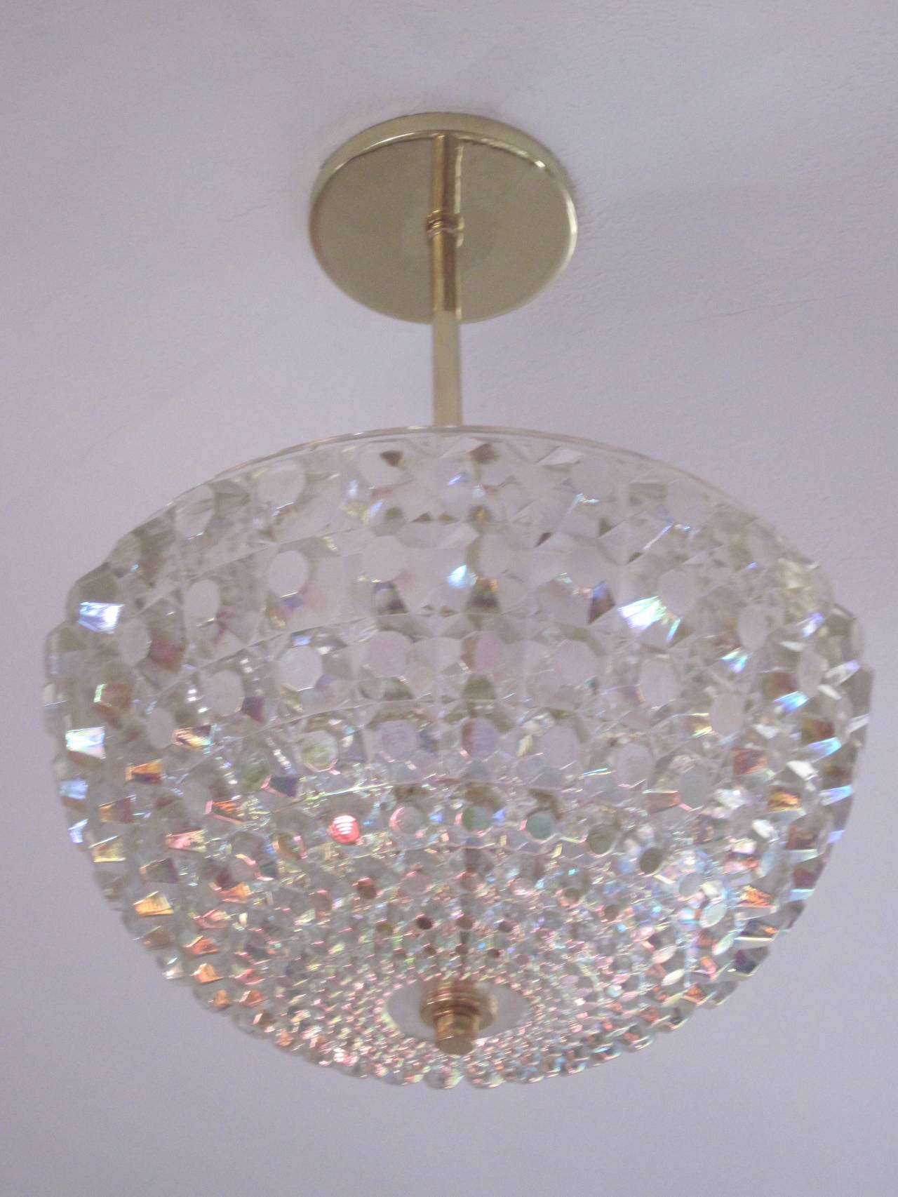 2 Austrian Mid-Century Modern cut crystal pendants or chandeliers attributed to Bakalowits and Sohne and cut in an octagonal pattern to defract and reflect light in a prism of muted color. Solid brass canopy, stem and finial. The current stem height