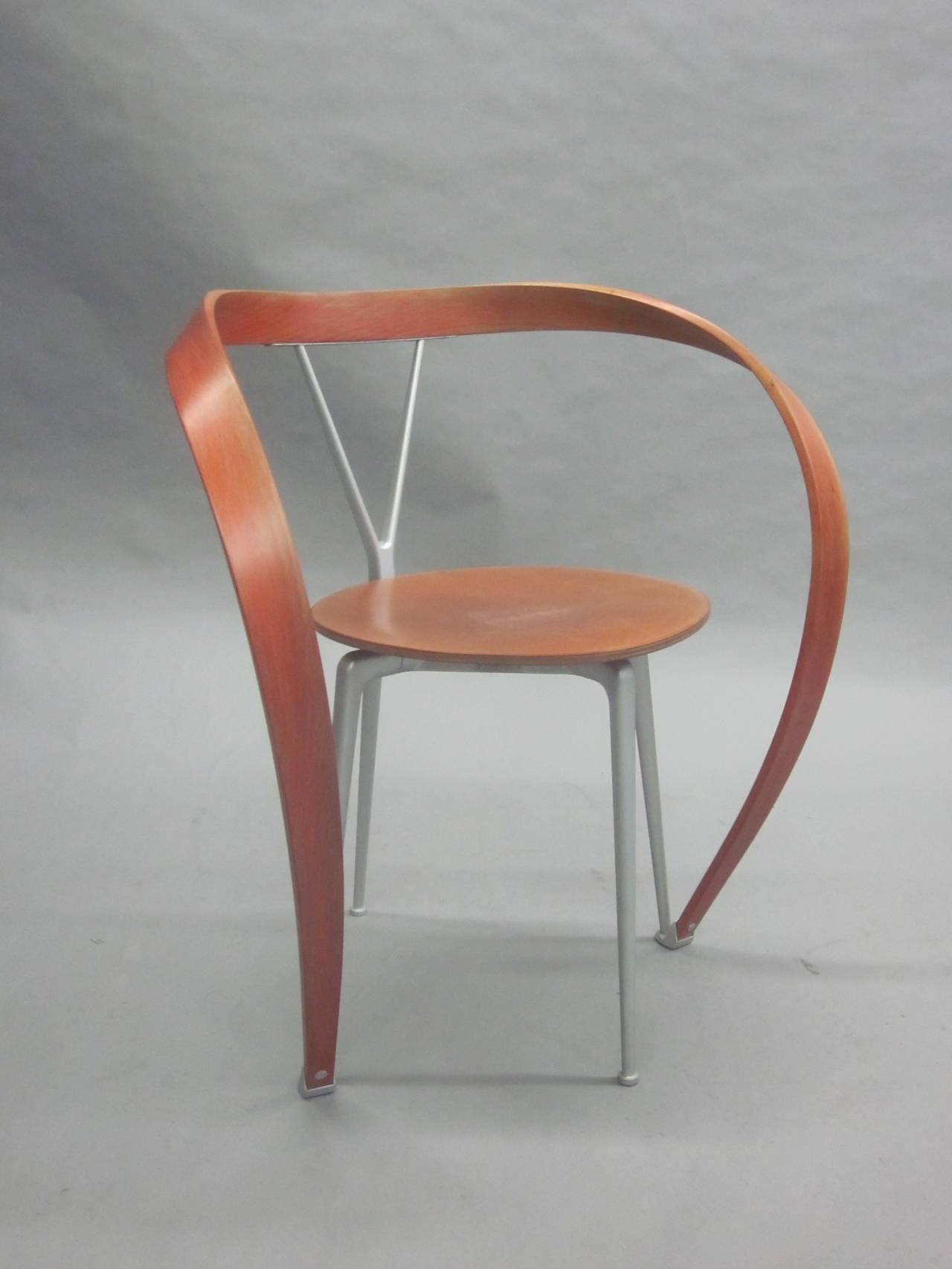 Un fauteuil design moderne iconique et visuellement époustouflant d'Andrea Branzi, avec une structure en acier anodisé mat, un support de dossier en bois de hêtre moulé et une structure d'accoudoir en forme de ruban inversé.

Hors production.