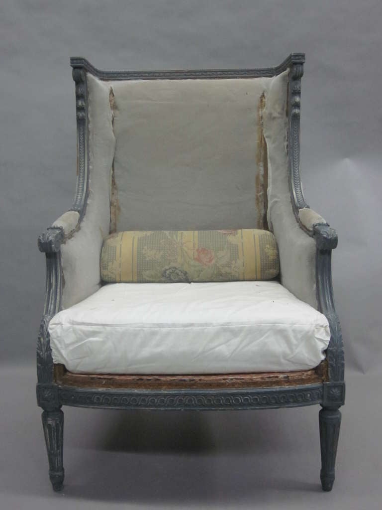 Pair of French Mid-century modern period high backed lounge chairs, armchairs, club chairs or bergere in the neoclassical Louis XVI style attributed to Maison Jansen with stunning form and blue-grey coloration of wood. 

'Shabby chic' upholstery,