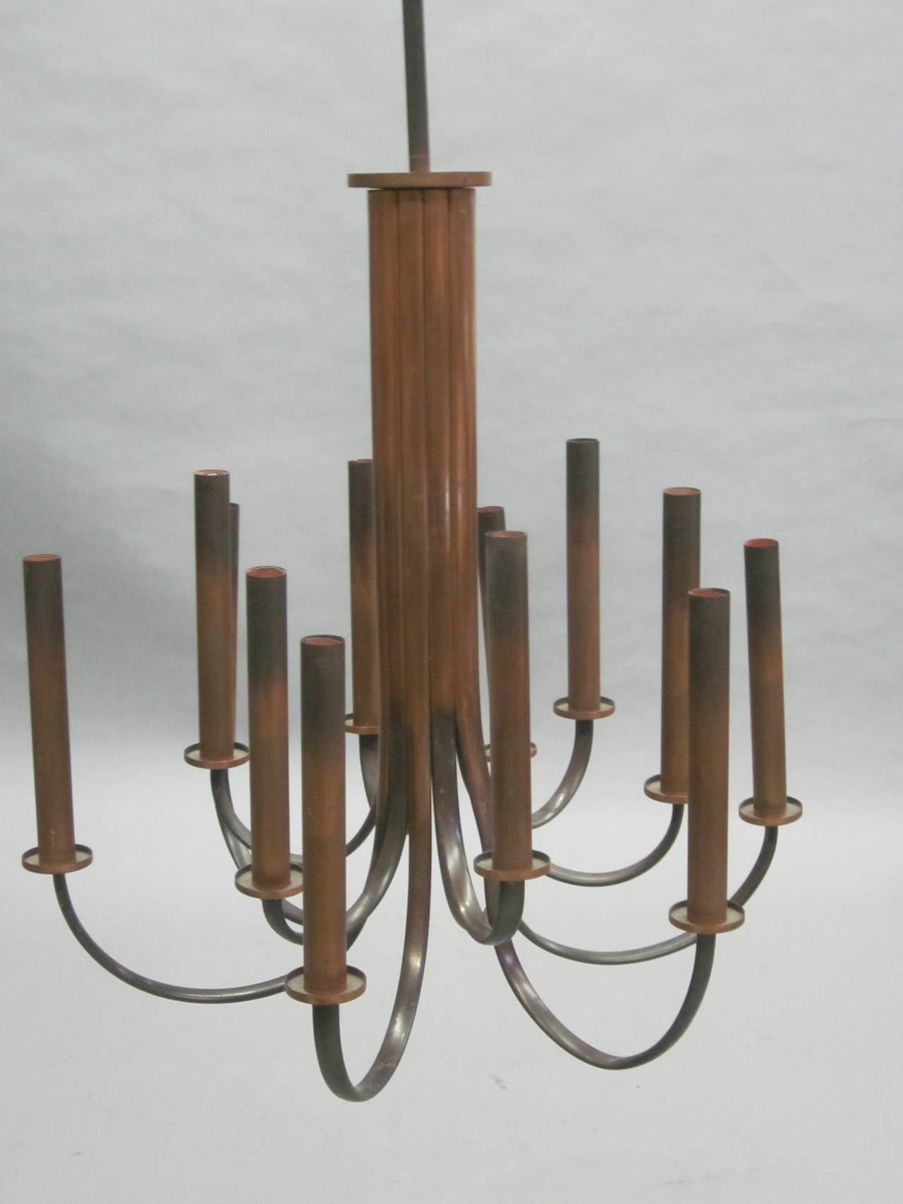 A Rare and Elegant French Post Art Deco Chandelier in Copper with 12 Dramatic Arms Arranged in a Sober, Modern Neoclassical Presentation with Tall Copper Candle Covers. 

Height of Chandelier without stem is 27.5