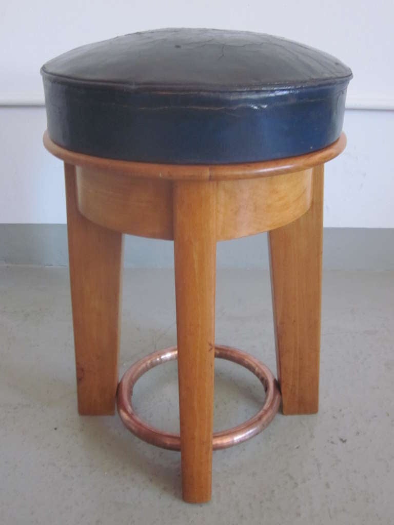 Elegant pair of French modernist stools in a rare design with strong tapered legs, a copper plated brass circular stretcher supporting seats of blue leather. 

Stamped Taubmann, Paris on internal frame.