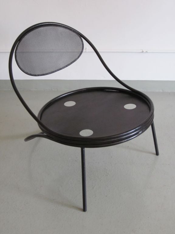 Rare pair of French Mid-Century Modern 'Copacabana' chairs in black enameled iron by Mathieu Matégot. These lounge chairs/armchairs are rich fantasy creations with their sweeping curved rear legs and transparent back supports reflecting both a