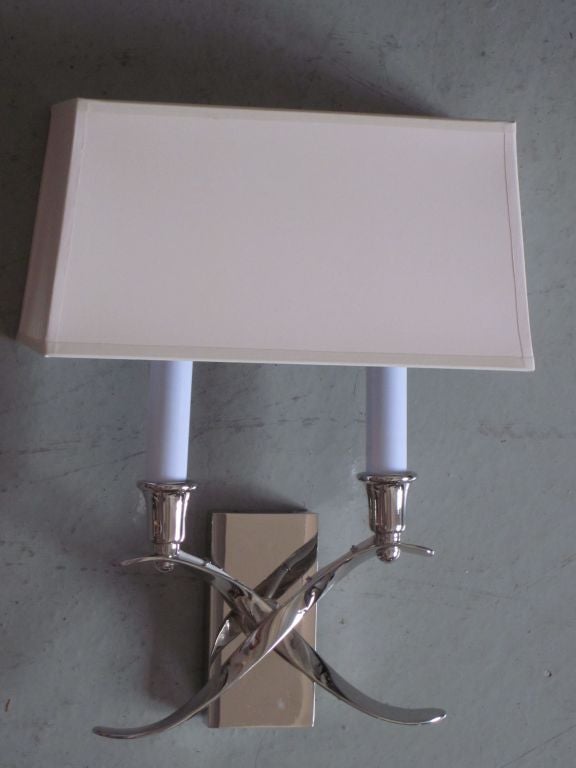 Pair of French Art Deco / Mid-Century style nickeled wall lights in a Modern Neoclassical X-form design. Each wired for two lights. Sold and priced as a pair.