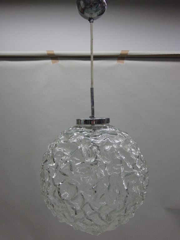 Pendente / lanterna o apparecchio da incasso in vetro soffiato trasparente in stile Mid-Century Modern. Il vetro ha una forma a fossetta.

L'apparecchio può essere montato a qualsiasi altezza desiderata, anche ad incasso, tramite la sostituzione
