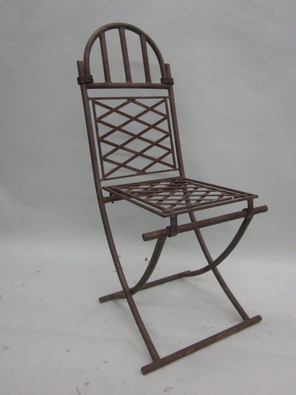 A Set of 4 Elegant French hand crafted wrought iron chairs attributed to Raymond Subes. The set is suitable for dining, lounge or use at a desk. The pieces have timeless quality and are in the Mid-Century Modern Neoclassical spirit with legs set in