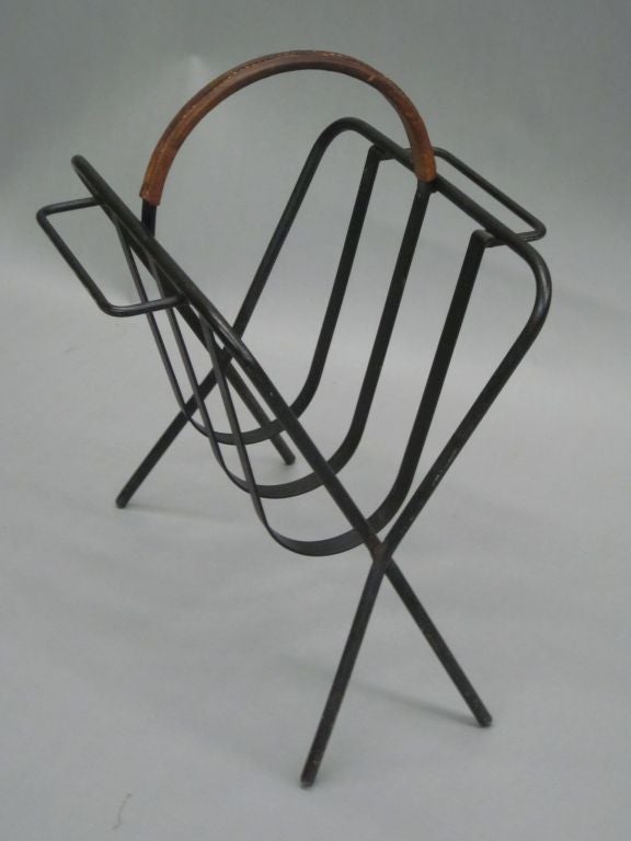 Chic French Mid-Century Modern magazine stand in black patinated wrought iron with a hand-stitched leather handle.