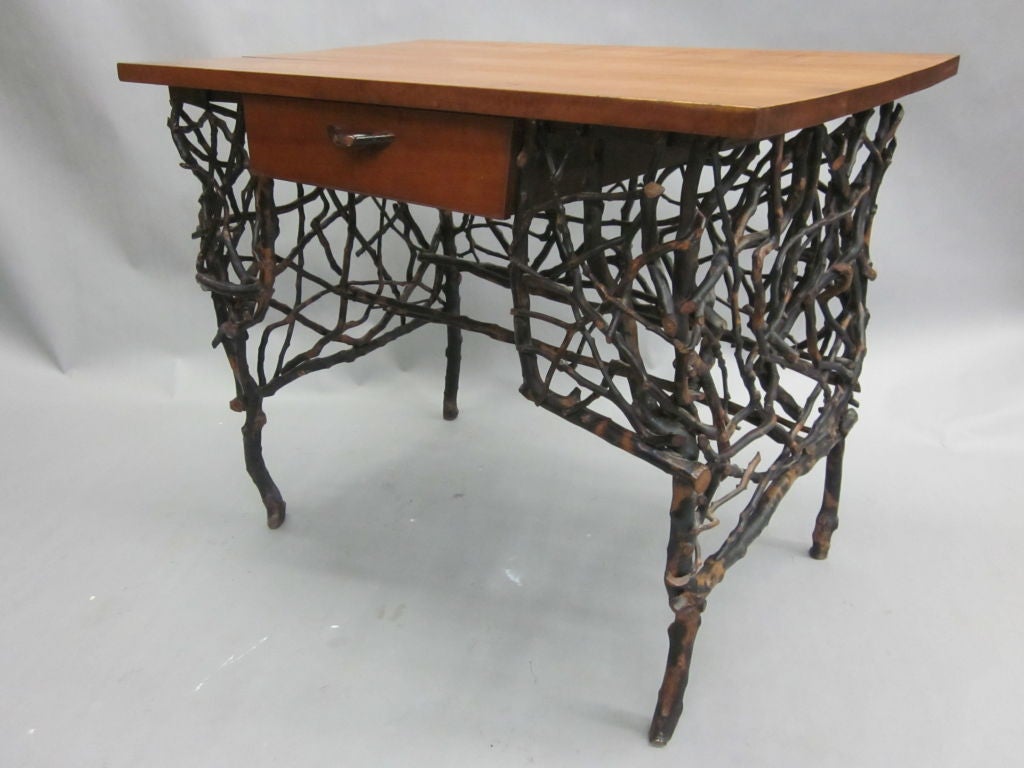 A rare, unique neo-primitive /modern craftsman desk attributed to Lee Fountain (1869-1941) and composed of a base of interwoven twigs supporting a top in cherry. Drawer has a twig handle.

This desk is unique in it's lightness of form,
