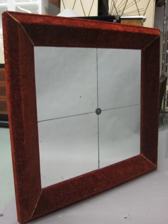 Rare Italian Mid-Century Modern Neoclassical Venetian wall mirror with an angular frame upholstered in antique velvet and composed of four naturally antiqued mirrored panels and with a central rosette.

Large, rectangular form with mirror inset into