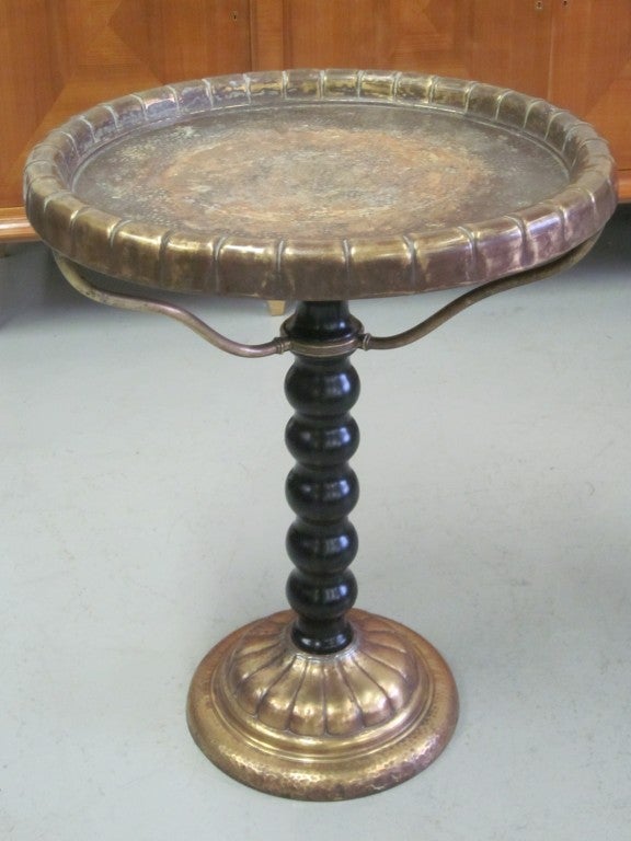 Elegant Italian Mid-Century / Novecento center table or side table with compelling materials, design and form. Hand-hammered brass and copper base, a turned ebonized wood supporting stem, tripod copper supports and a hammered copper top are all