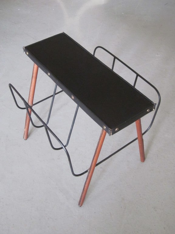 Elegant French Mid-Century Modern handstitched leather bench / magazine rack by Jacques Adnet. The top of the frame is wrapped in black leather and the legs in light brown leather.

Literature: See Jacques Adnet by Alain-Rene Hardy and Gaelle