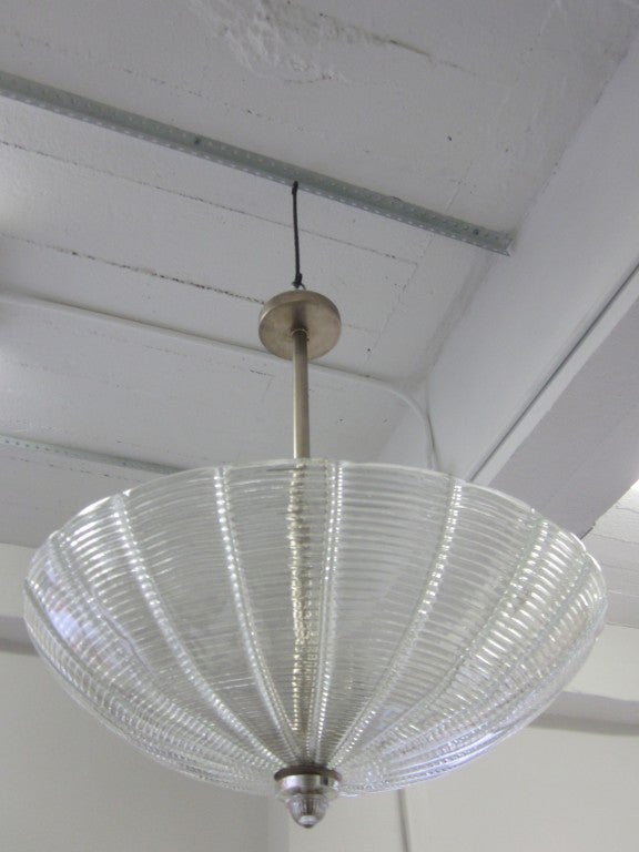 Large Italian Mid-Century mold blown Murano glass chandelier / pendant formed of thick, ribbed clear glass. Nickel stem and canopy. Re-wired with three Edison sockets.

A second smaller piece with a diameter of 20.5" is also available.