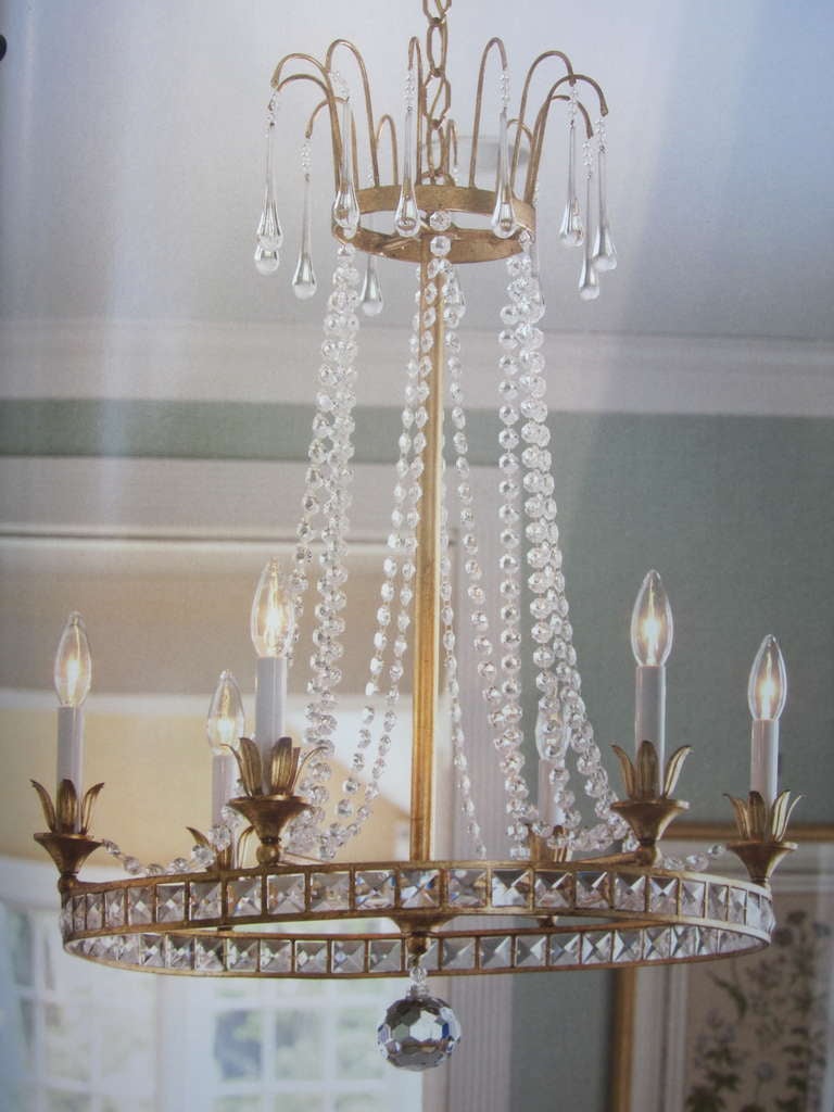 Pair of elegant Louis XVI style chandeliers in a stunningly pure design and the highest quality of craftsmanship. 

These modern neoclassical pieces in the style of Maison Jansen are composed of a gilt wrought iron frame with inset cut crystal,