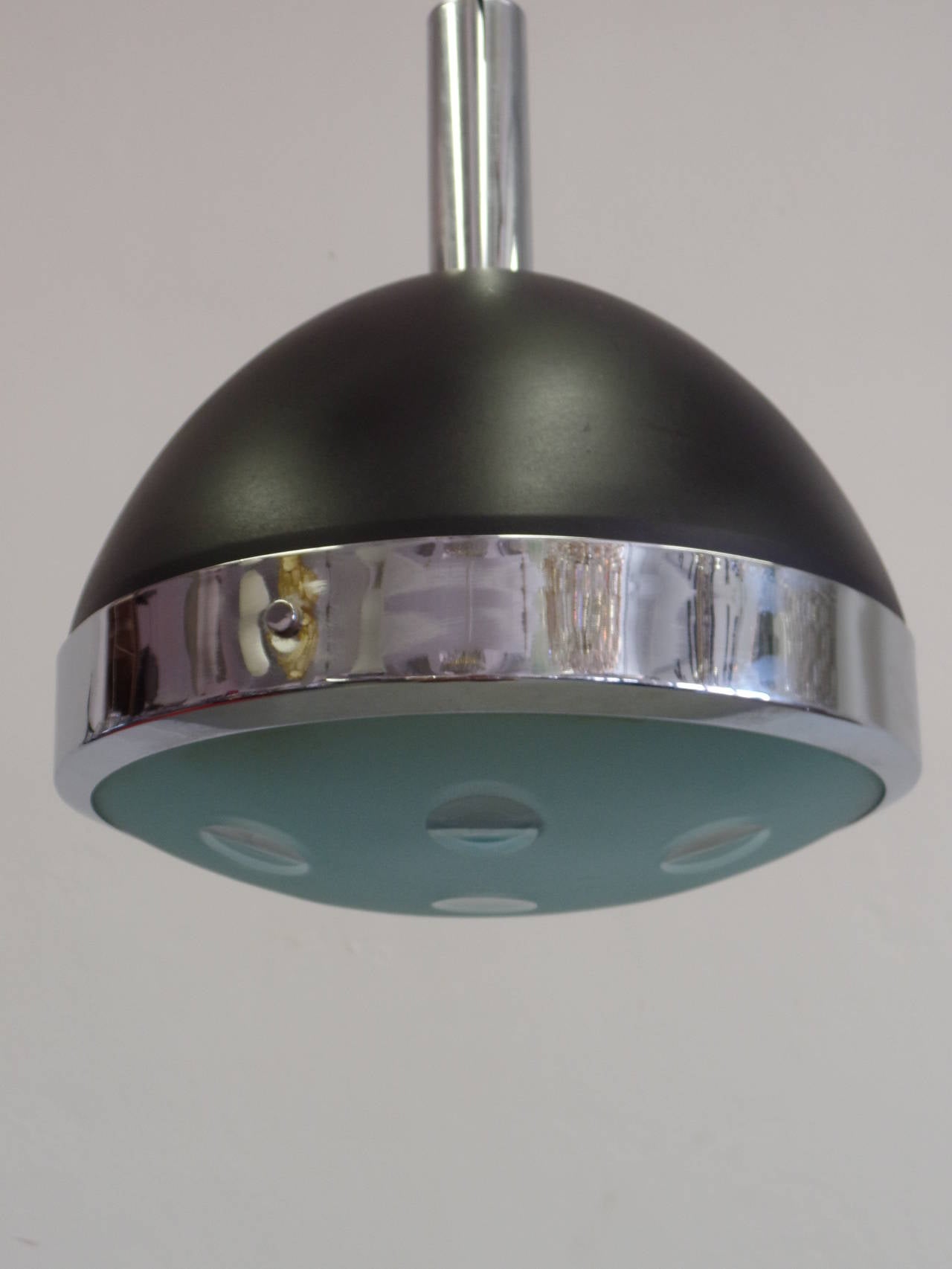 Three elegant Italian Mid-Century Modern pendants or flush mount fixtures by Stilnovo with engraved circular patterns. The frames are enameled black metal with chrome banding and detailing. 

Height of fixture alone is 14