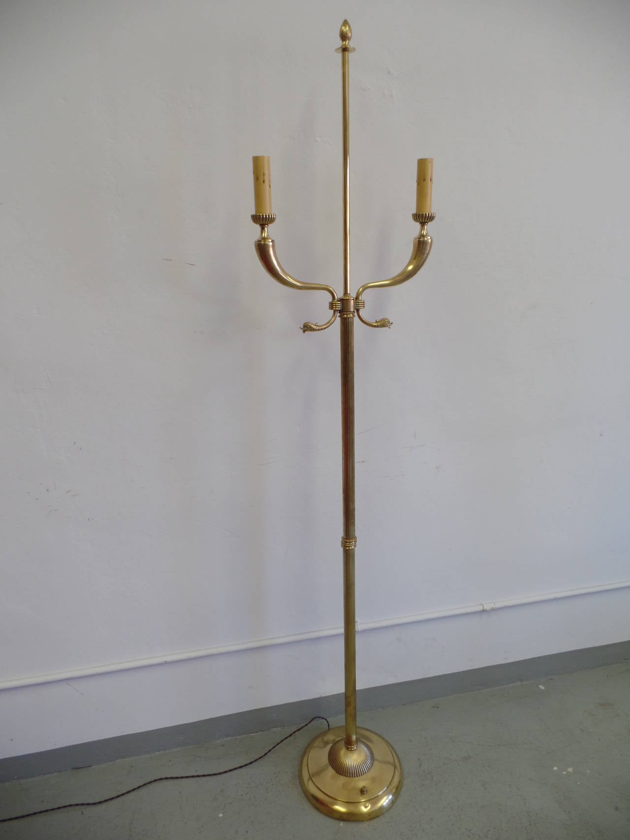 Rare, Elegant pair of large Italian brass standing lamps in the Modern Neoclassical style with a double horn form characteristic of Tomaso Buzzi and Gio Ponti. Each lamp is fluted and has a sunburst form on the base.