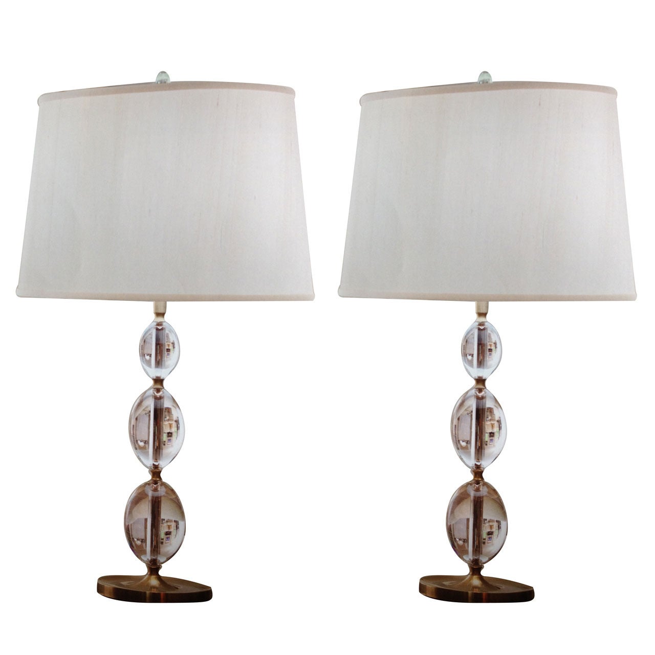 Two elegant pairs of Italian glass table lamps with three solid crystal spheres stacked on solid brass bases in a sober, modern presentation.

Priced and sold by the pair. 

 
