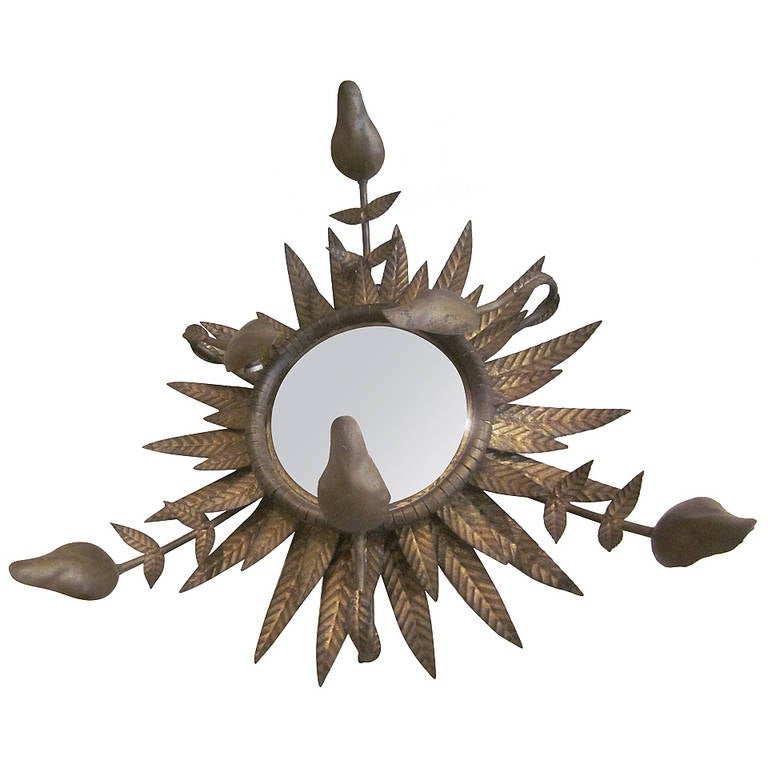 An Exceptional French modern neoclassical, 1940s pendant / flush mount fixture with a central convex mirror. The entire piece is composed of gilt iron leaves in the form of a sunburst. There are six blooms arising from the leaves that each contain a