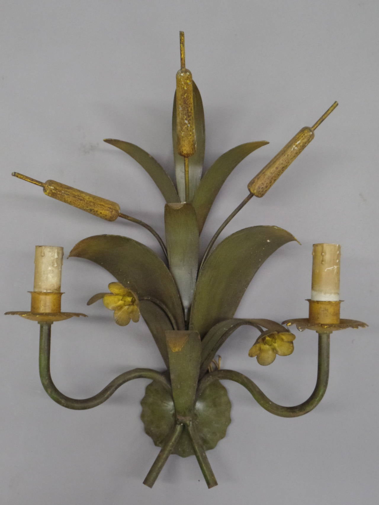 Pair of elegant, handmade French Mid-Century circa 1940 wall lights in painted toll with a floral cattail motif. Each sconce holds two candelabra lights. 

Priced and sold as pairs. Can be wired to specification.