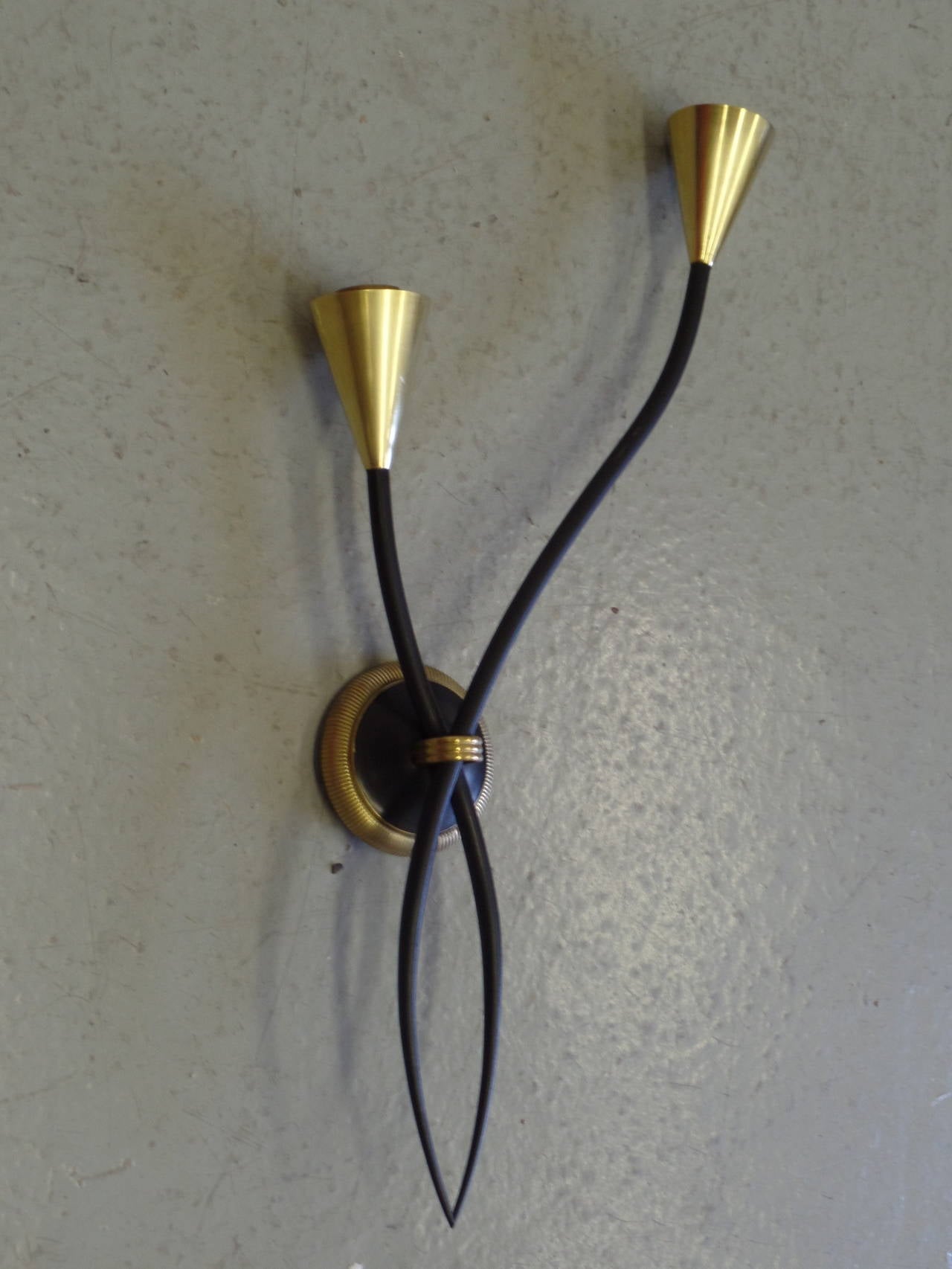 One pair of poetic Mid-Century Modernist wall lights by Jean Royère. These double arm pieces have pure, graceful lines and delicate balance. Each sconce takes two candelabra sockets. 

Literature: A similar pair of Royère sconces was sold at Etude