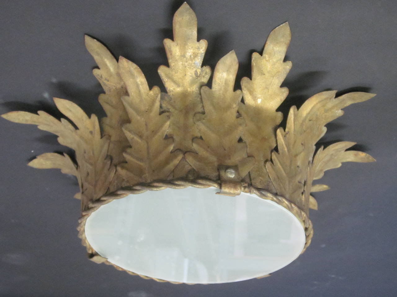 A French 1940 Gilt Iron Flush Mount Fixture in the Modern Neoclassical Spirit with a Sunburst / Starburst Form. This piece can also suspend as a pendant with addition of a stem.