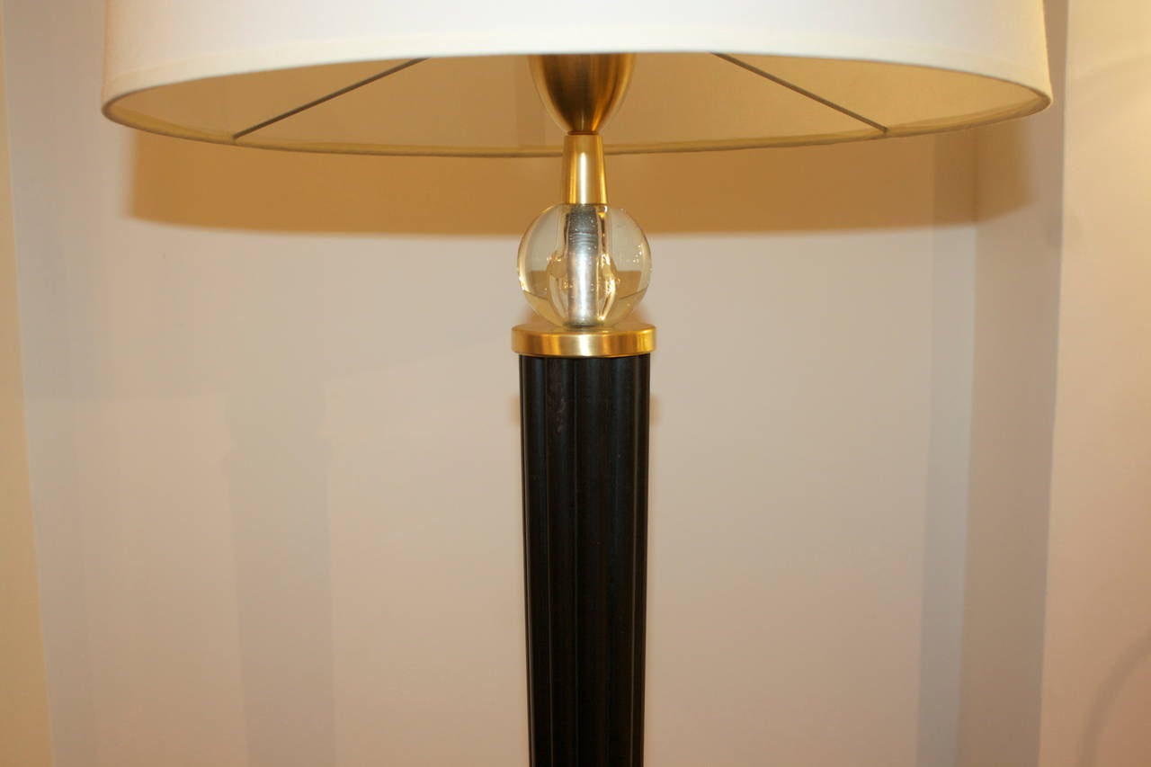 Italian floor lamp with cylindrical mahogany stem carved with channels.
Beautiful brass legs with crystal sphere accent and paper shade, diameter:
18