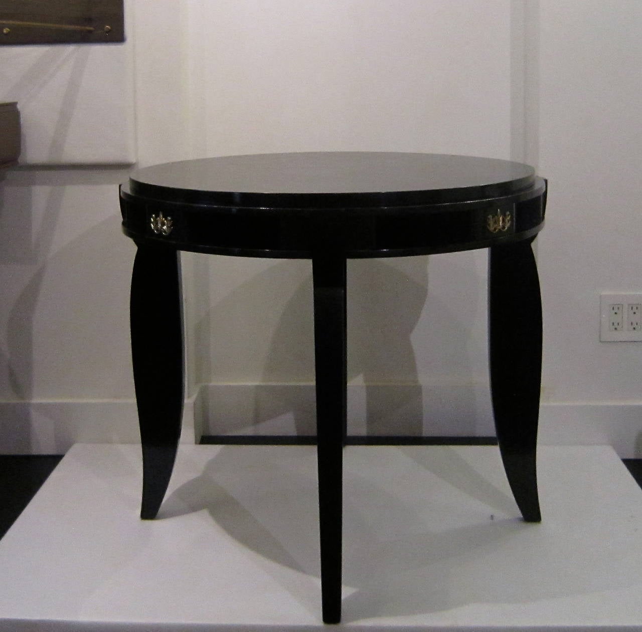 Ebony lacquered game table in the style of Jules Leleu. Designed with compartments for game accessories etc. with elegant curved legs. Beautiful detailing with bronze accents.