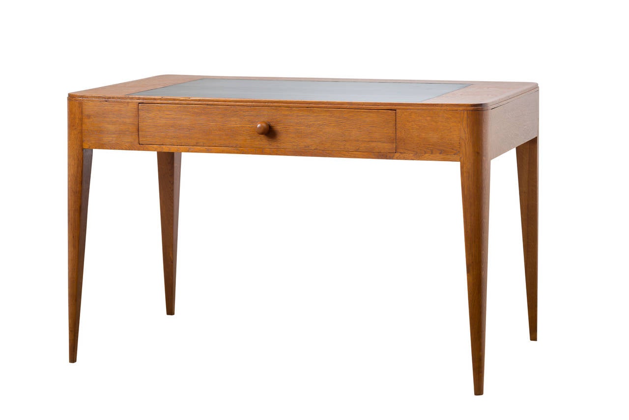 Oak desk with rounded corners, original linen blotter, tapered legs signed by Émile Jacques Ruhlmann.