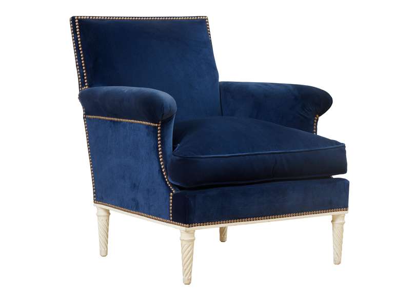 An upholstered armchair with carved and painted wood frame designed by Maison Jansen and later covered with navy mohair velvet.
