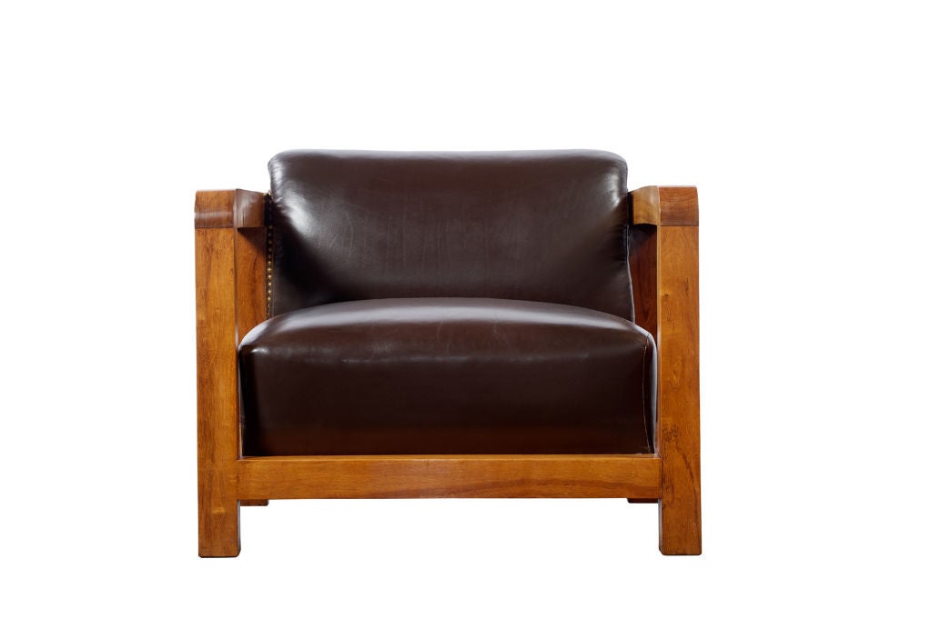 A leather and walnut upholstered armchair with nail head detail. Attributed to Jacques Adnet (1904-1984).