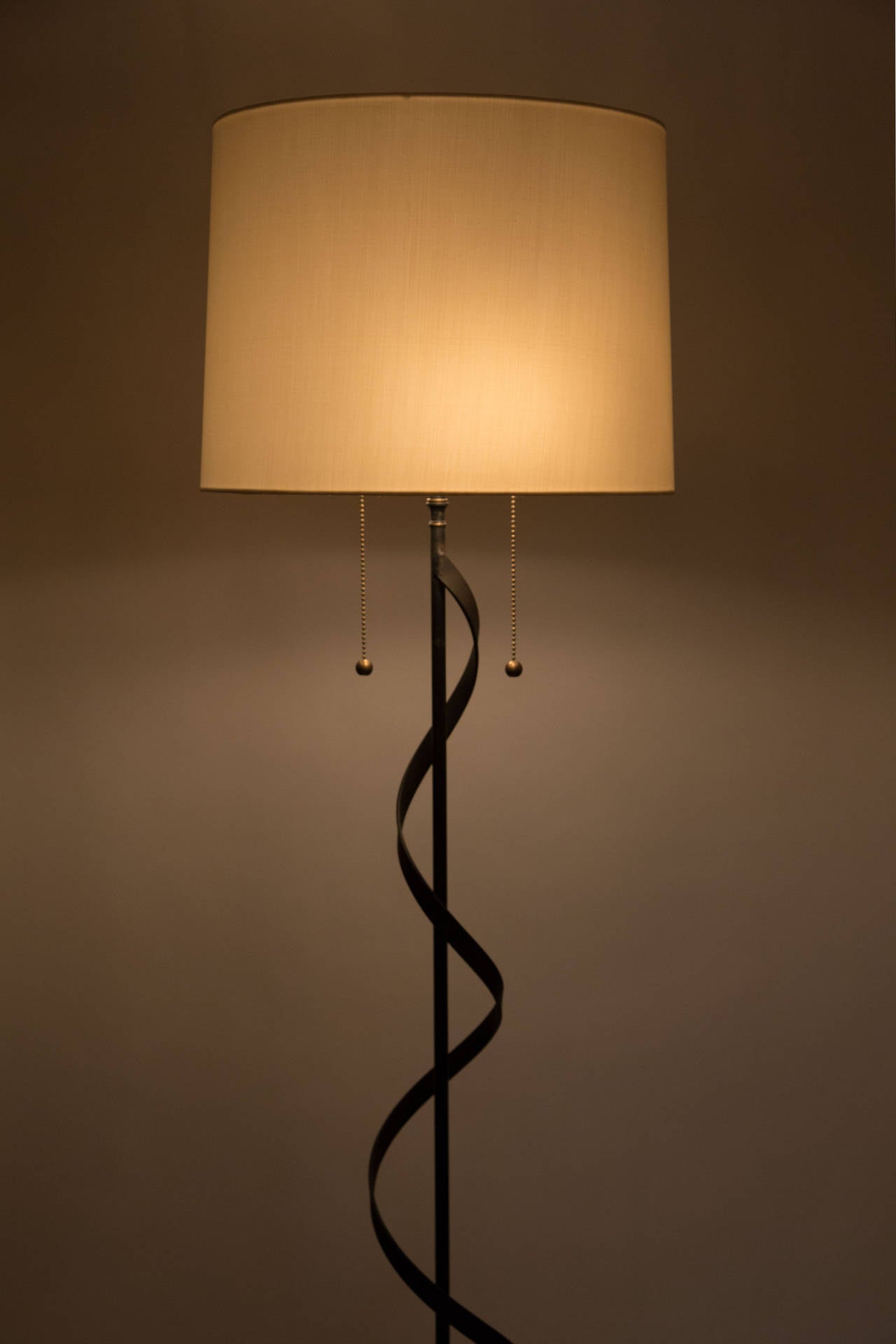 An iron 1950s floor lamp with a custom silk shade.