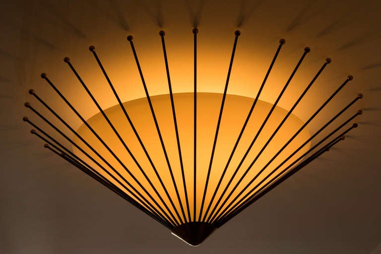 Satin glass shade suspended in black wire and brass detail.