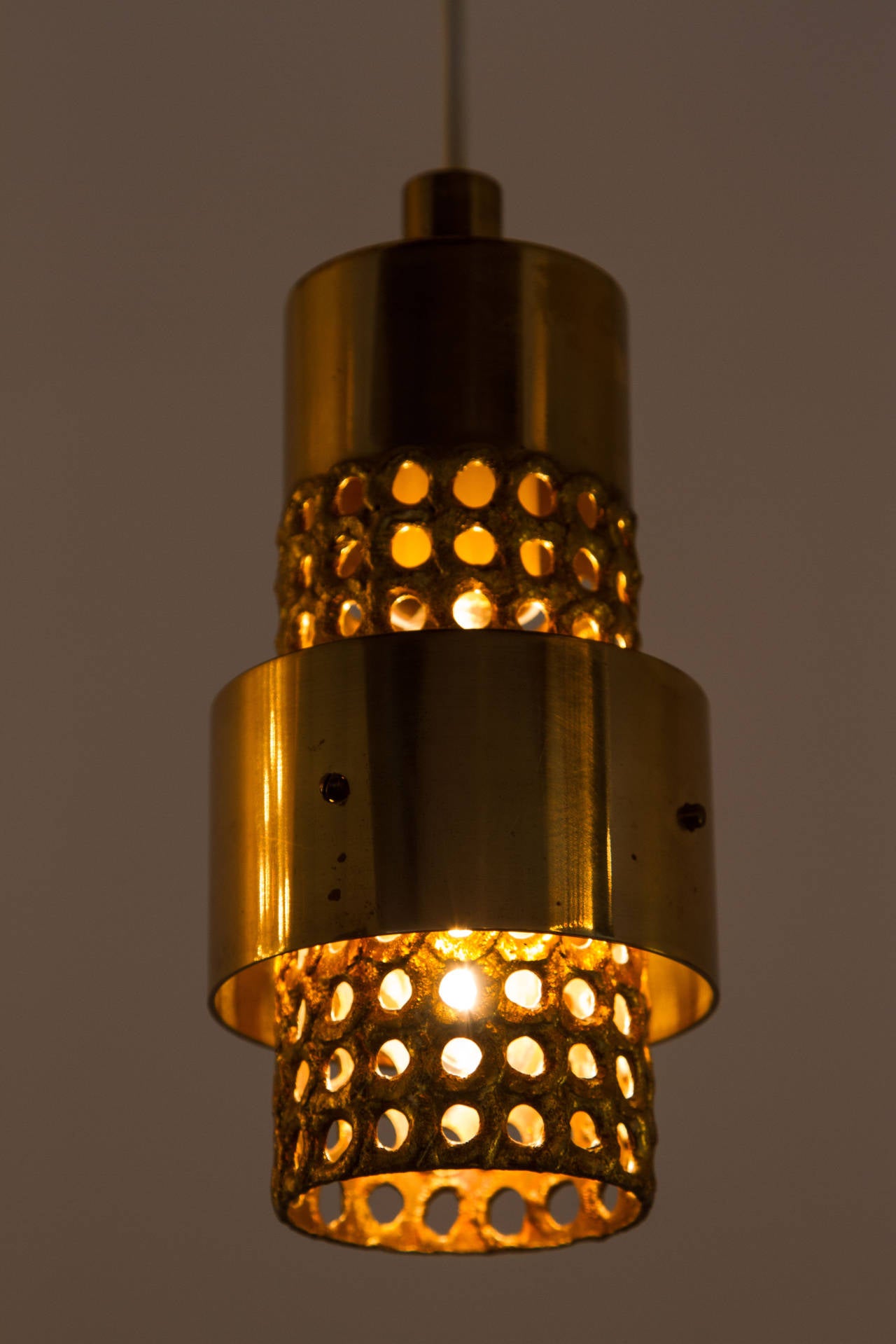 Petite polished and textured perforated brass pendants.