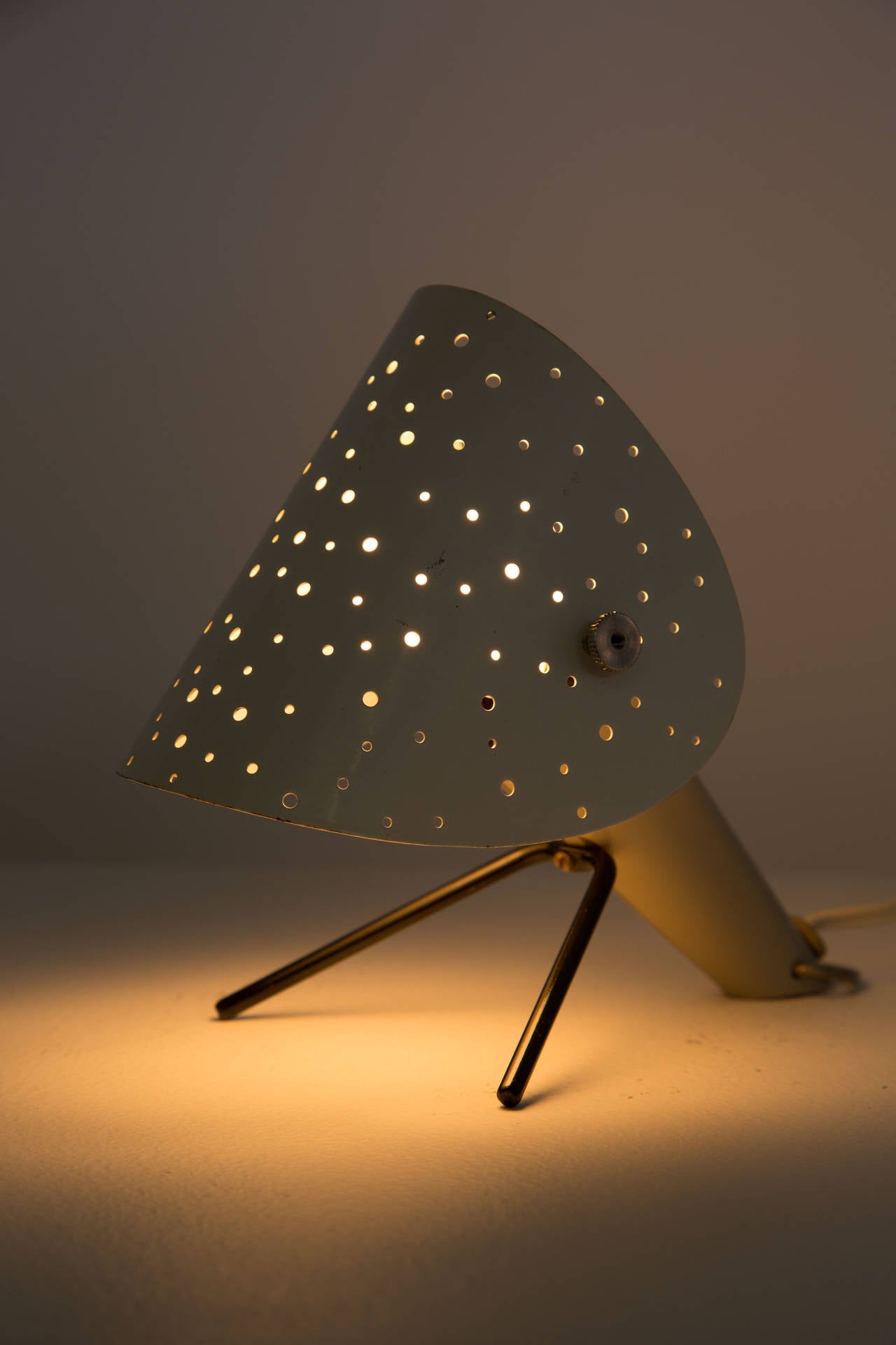 Table lamp with a rare shape and perforation layout on the shade. 
Shade adjusts up or down.