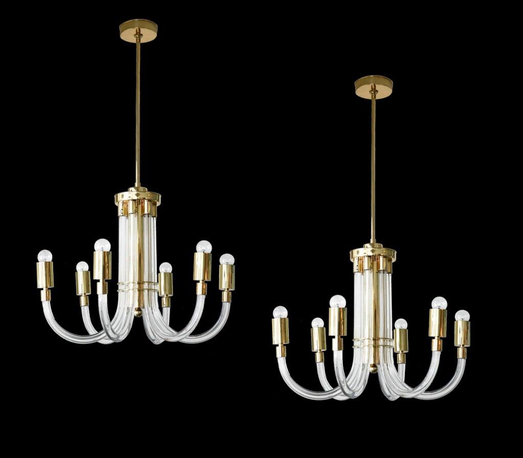 Pair of acrylic and brass chandeliers.