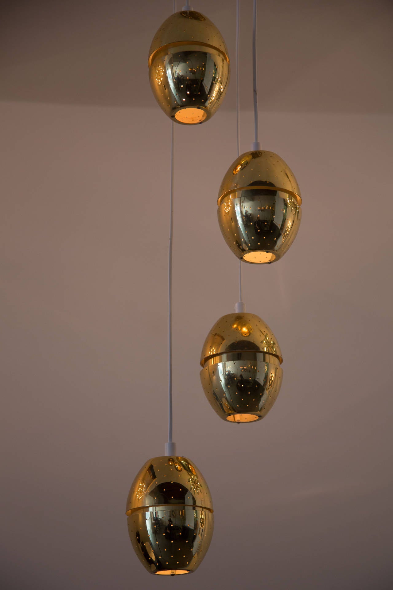 Hans-Agne Jakobsson Chandeliers. 
Grouping of four brass, perforated pendants.