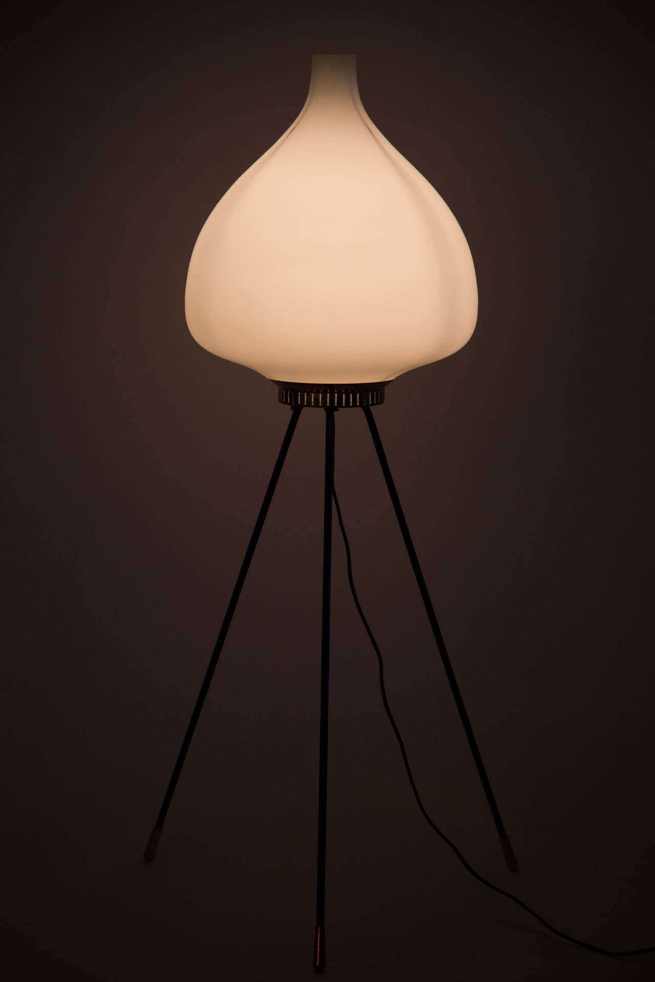A tripod standing floor lamp with opaline glass globe
