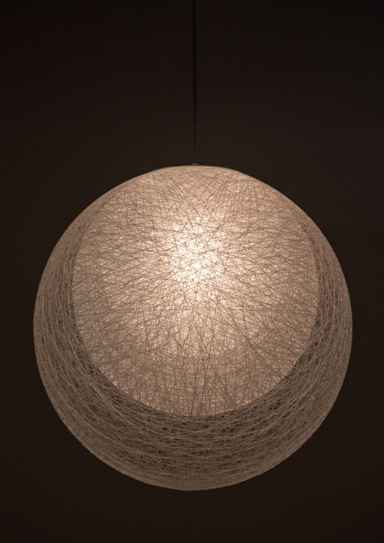 Un pendentif composé de trois globes concentriques en acrylique filé.
