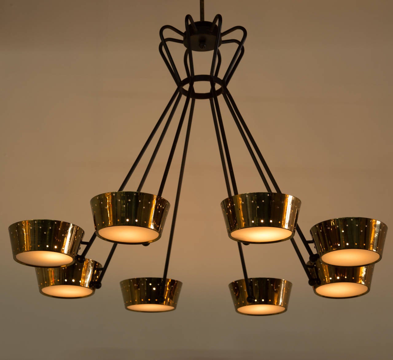 Brass and metal eight-arm chandelier with perforated shades.