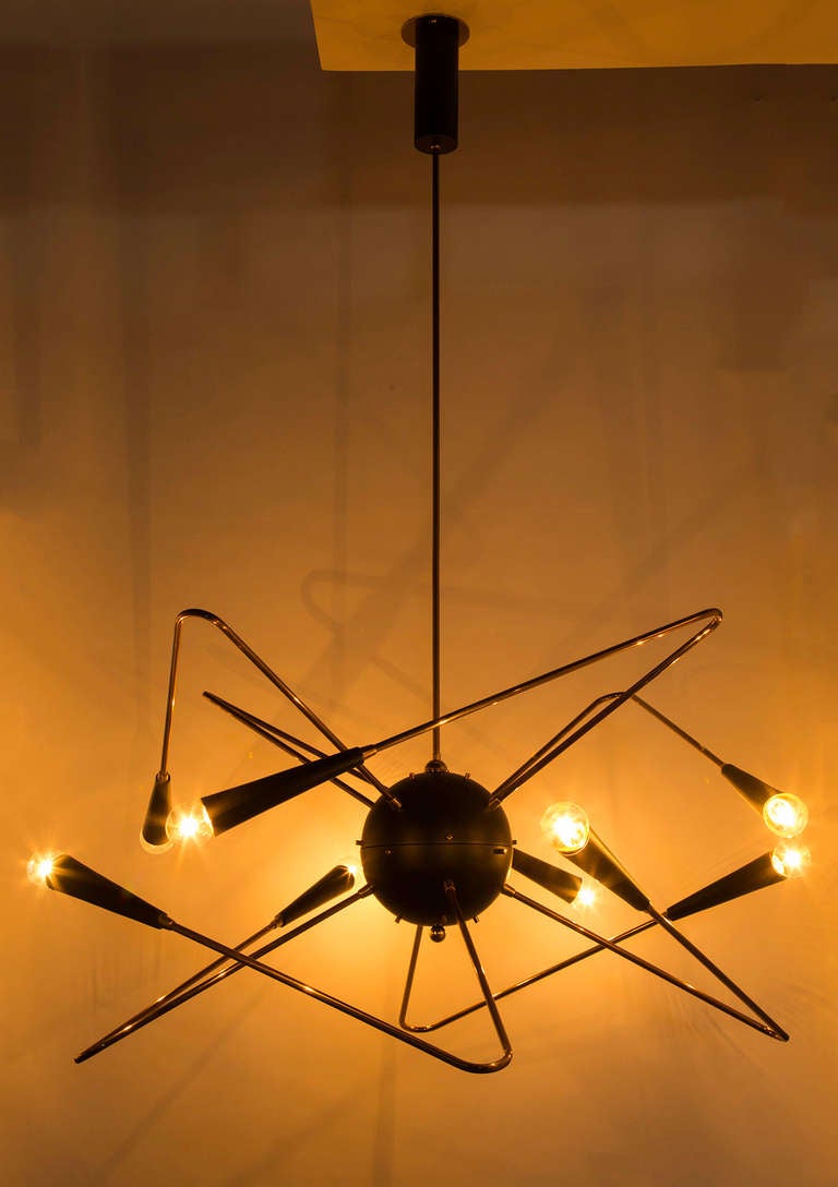 Black and brass chandelier with eight arms.