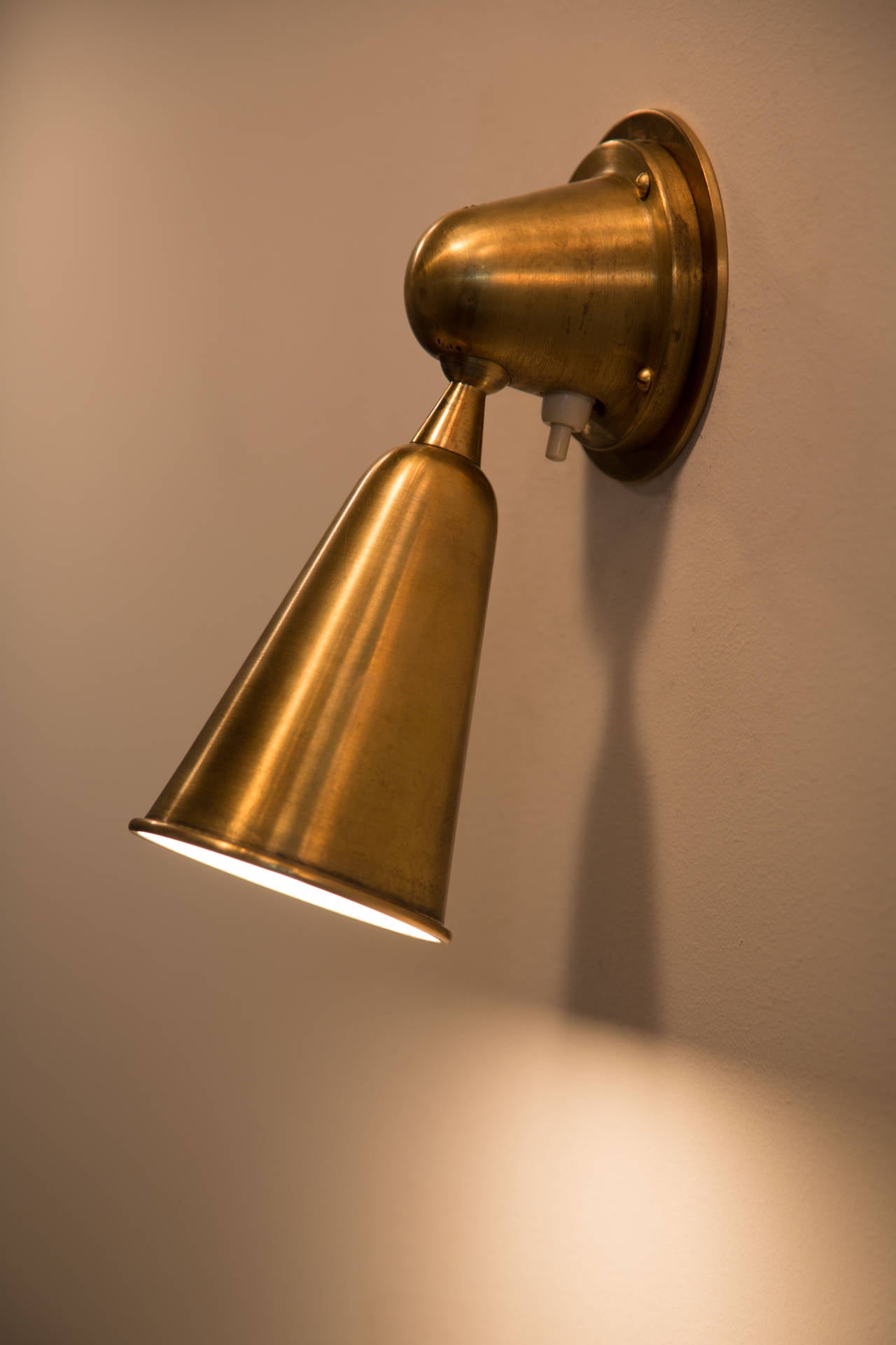 Satin brass sconce with fully pivoting shade.