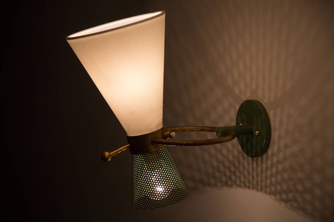 Polished brass sconces with double shades of silk and perforated metal. Two switches and custom back plates for each.