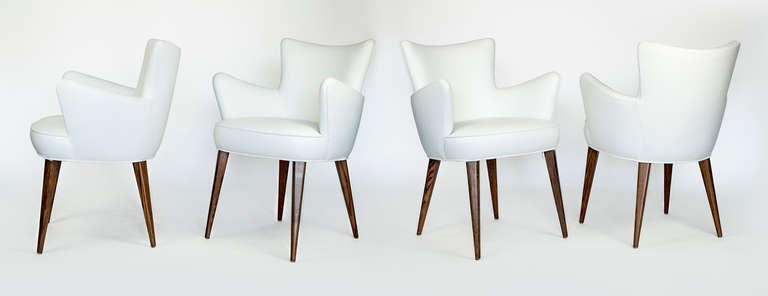 We upholstered these four chairs in white leather.  They have oak legs stained in walnut.