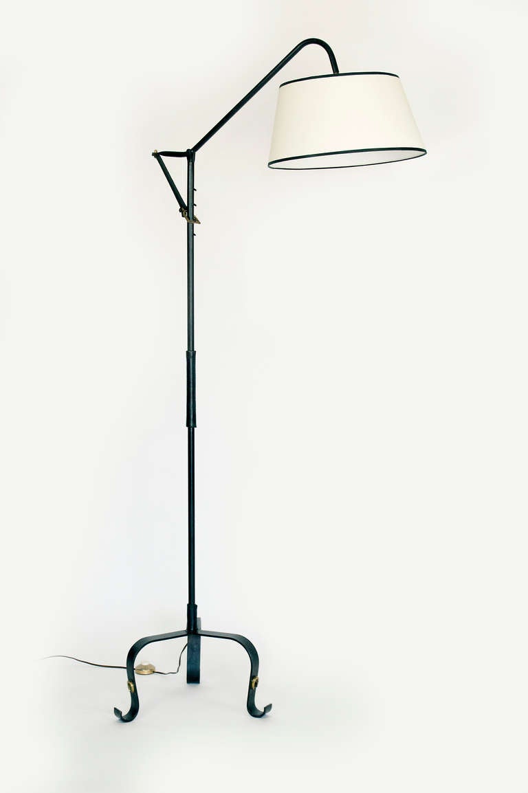 Adjustable Jacques Adnet floor lamp for Hermes.  Signature leather details of the designer, and the equestrian brass details synonymous of Hermes.  Linen shade.  Lamp uses on french bayonet light bulb,  an adapter for a medium socket bulb in