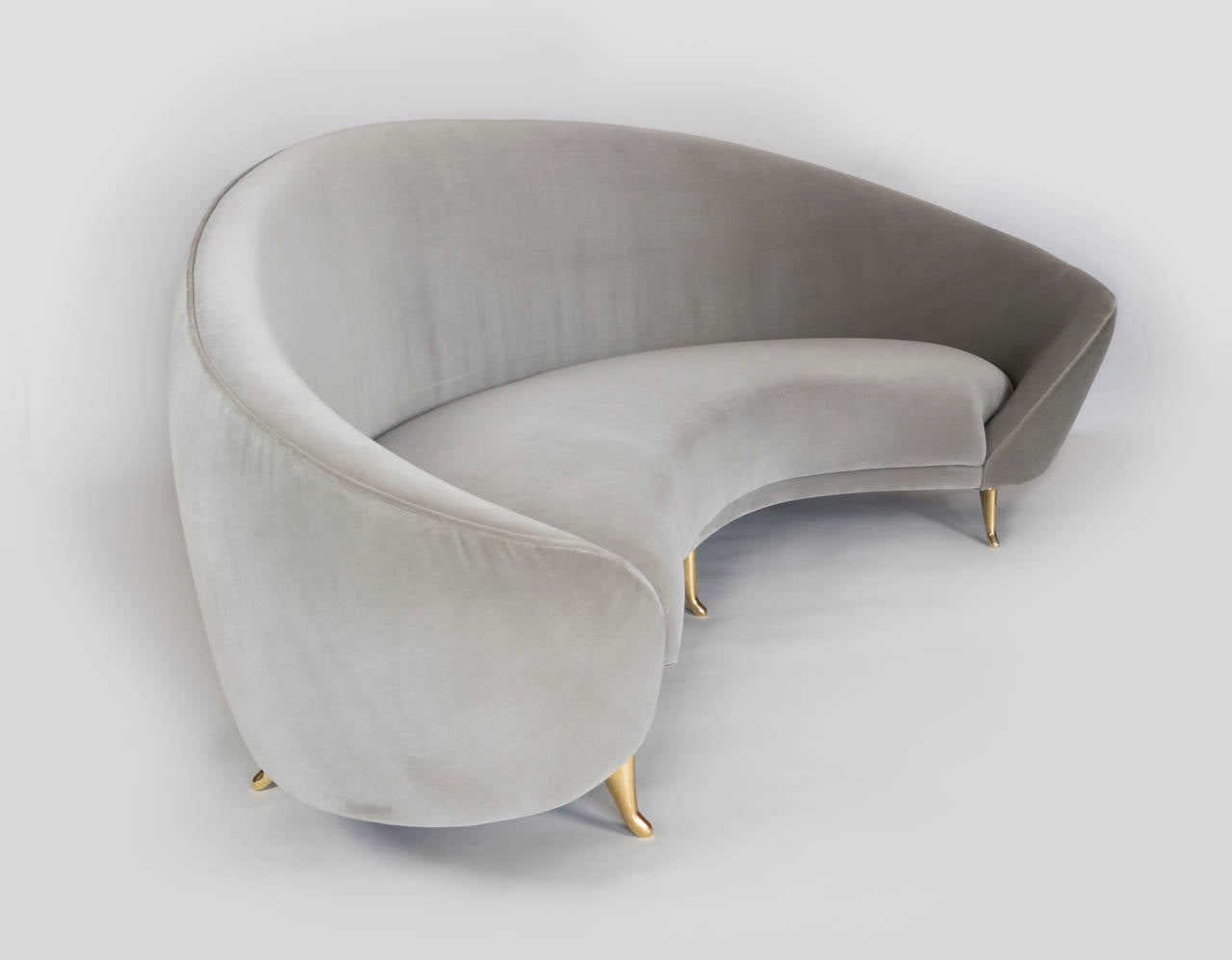 This chic sofa, reminiscent of the 1960s, has elegant lines with gracious curves. The brass feet add to its sophistication with their delicate design. It will surely be the focal point of any room.  The kidney shape of the sofa provides plenty of