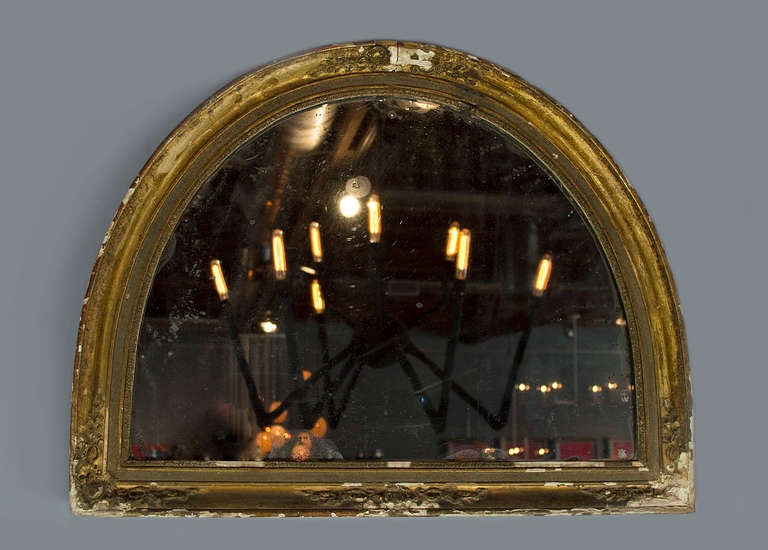 France 
1870
This hard to find half circular mirror with its original mercury mirror with extensive sugaring. This occurs in antique mirrors when the air molecules have broken down the mercury backing. This gives the mirror a shimmering effect and