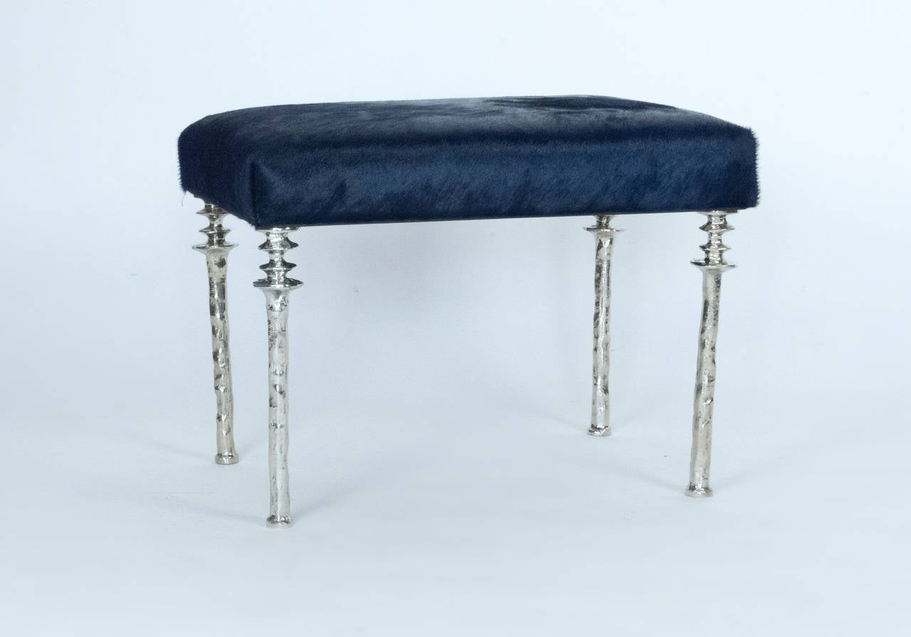Two beautiful stools inspired by Diego Giacometti, these stools are ideal for those who are looking for unique seating. Their cast white bronze legs provide a truely organic touch. The seat cushion has been upholstered in a navy blue cow hide. These
