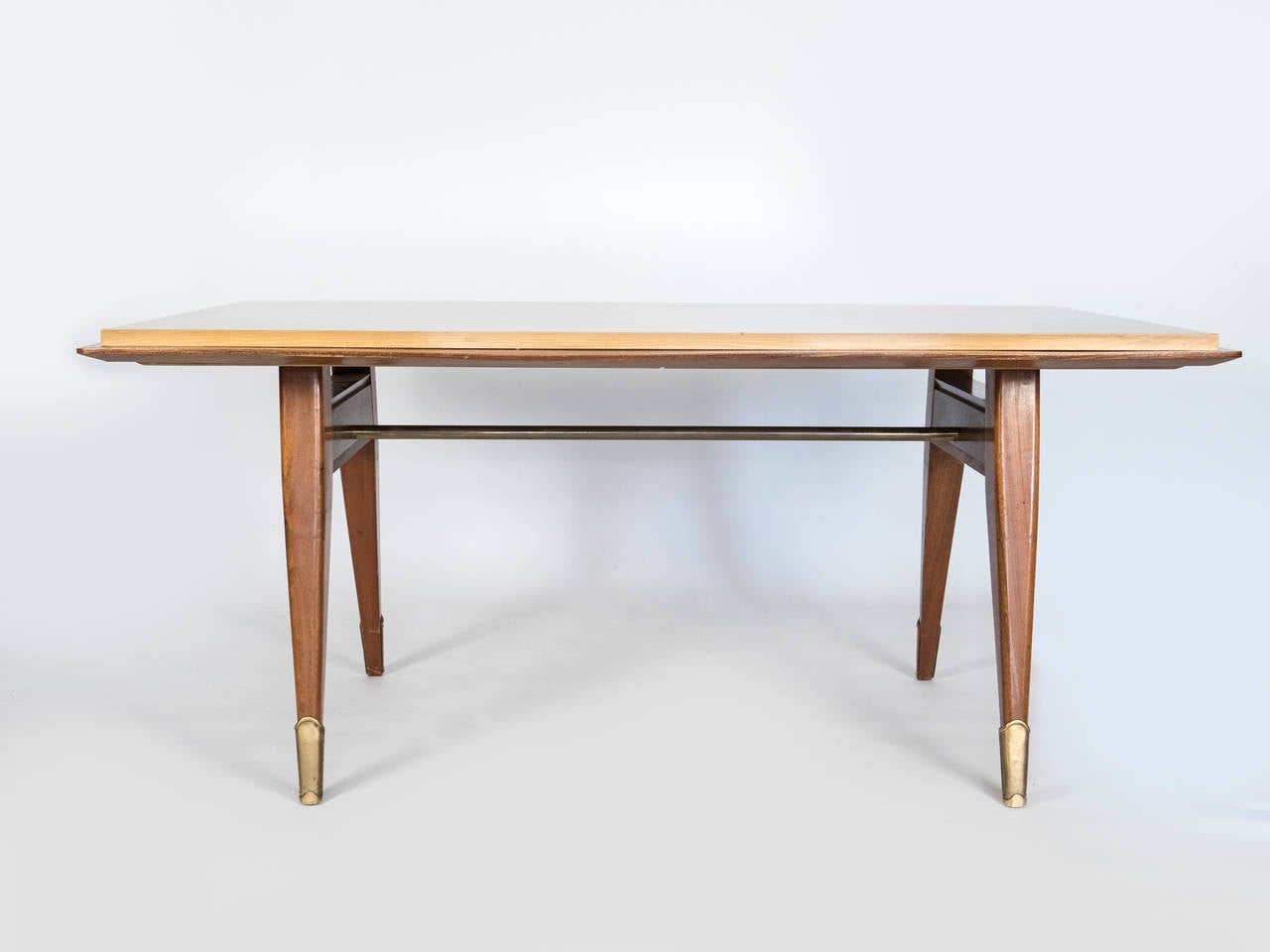 Esta mesa con base de caoba y tablero de sicomoro tiene un diseño único.  
Los elementos de latón acentúan las patas y la barra transversal.  Asientos cómodos para seis personas.