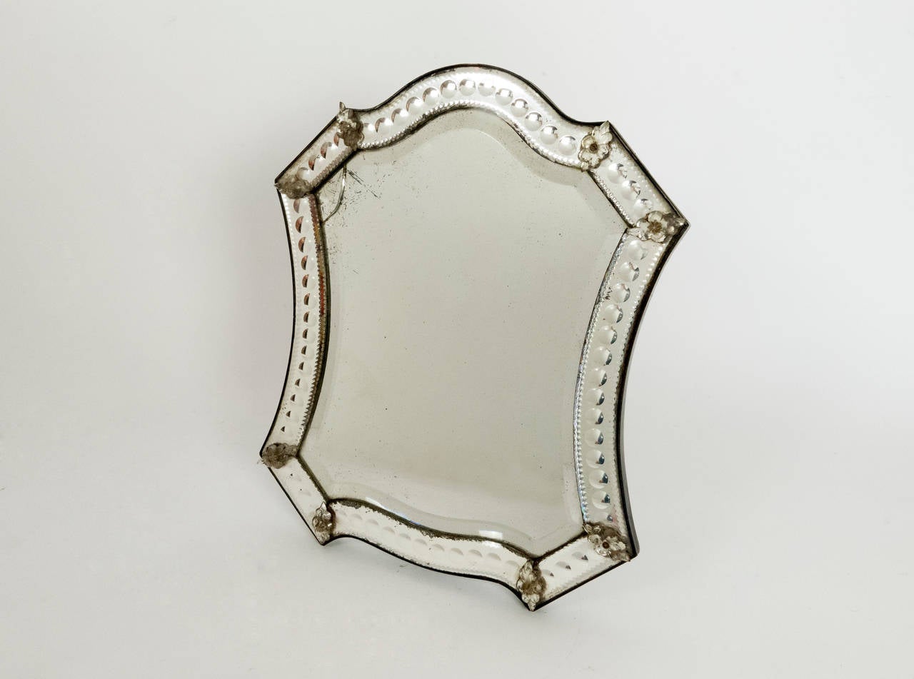 This mirror has a unique system which allows it to stand by itself on a table.  the leg can also be closed so the mirror can be hung on a wall.  All original mirror.  One small crack in the main mirror which is not dramatic, it adds history and