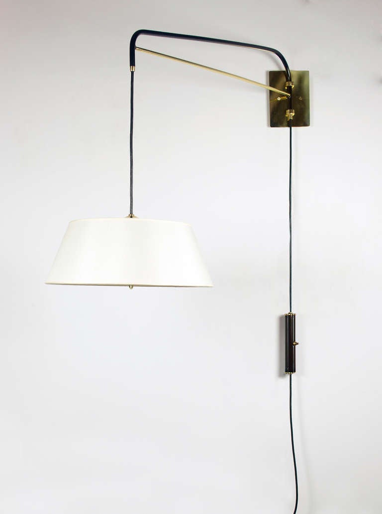 This graceful wall sconce is hand crafted with a black enamel finish and polished brass. An elegant linen shade ( 15