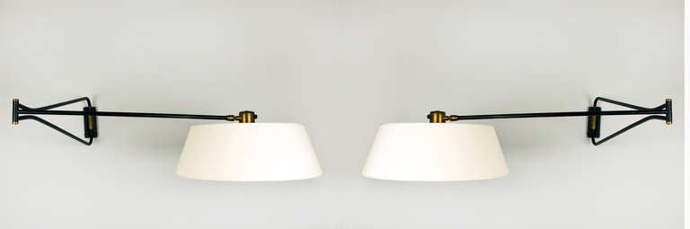 A matching pair of the large model of these sconces designed by Rene Mathieu.  This light manufactured by Lunel is articulated making it a versatile wall light.  The brass accents have a beautiful patina.  the shades have been redone in white linen.